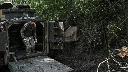 A Ukrainian soldier and a Bradley armoured vehicle close to the front line in Ukraine’s Zaporizhzhia region. Picture: Reuters