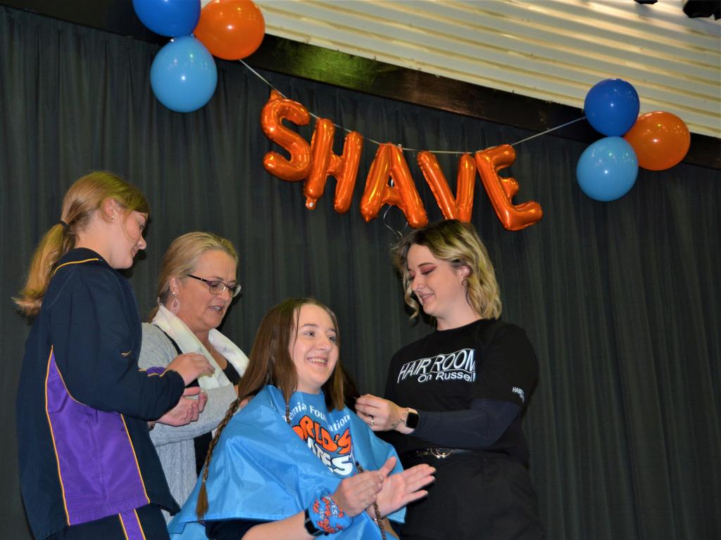 At the St Joseph's College 2023 World's Greatest Shave event is student Eve Bonell getting her cut by her support crew and hairdresser Natalie Schmidt (right) from the Hair Room on Russell. Picture: Rhylea Millar