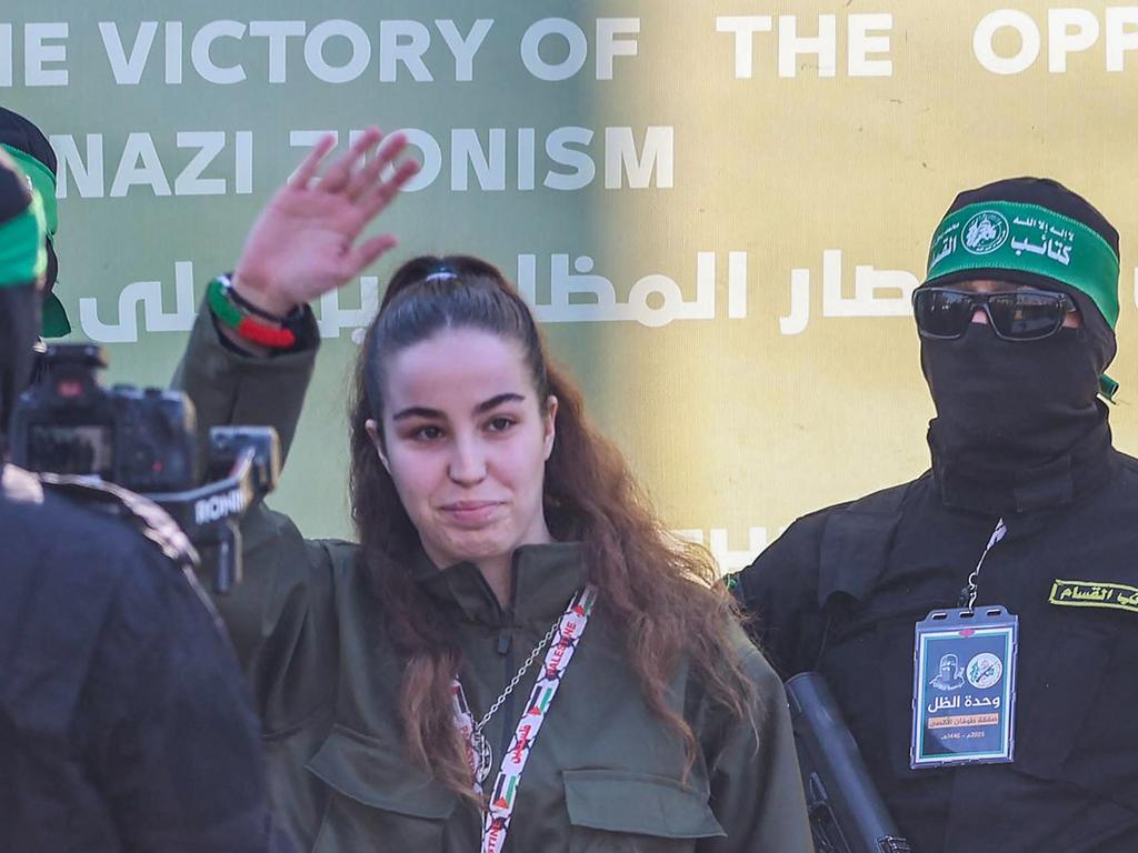 Israeli hostage Agam Berger waves as Hamas militants escort her on stage before handing her to a Red Cross team in Jabalia as part of their third hostage-prisoner exchange. Picture:AFP