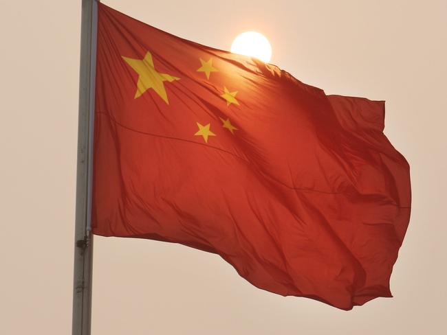 Beijing Olympics 2008. Sights and personalities around Tiananmen Square Beijing China. The sun seen through the thick haze over the People's Republic of China flag at Tiananmen Square, Beijing.