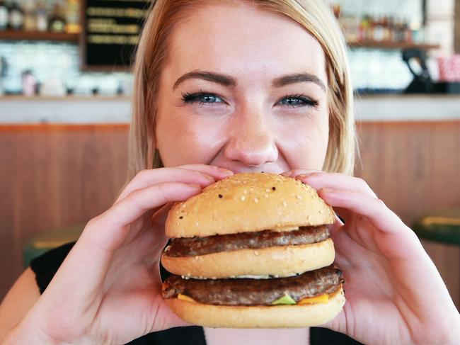 Ailish Harding poses with a Big Pac burger at Burger Urge in Windsor, Brisbane on Wednesday, November 14, 2018. McDonalds have issued a cease and desist letter to the burger business. (AAP Image/Claudia Baxter)