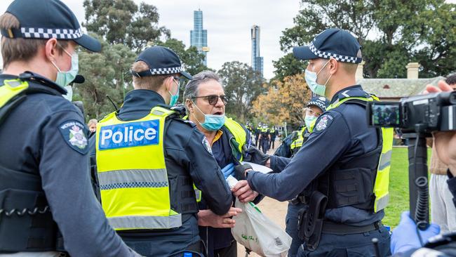 Police speak to a suspected protester. Picture: Jake Nowakowski