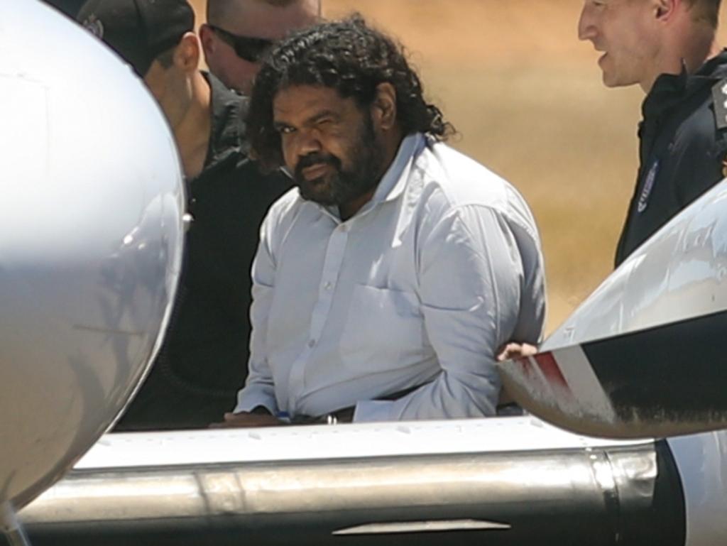 Terence Darrell Kelly boards a plane after being taken into custody by members of the Special Operations Group at Carnarvon airport on November 5, 2021. Photo by Tamati Smith/Getty Images.