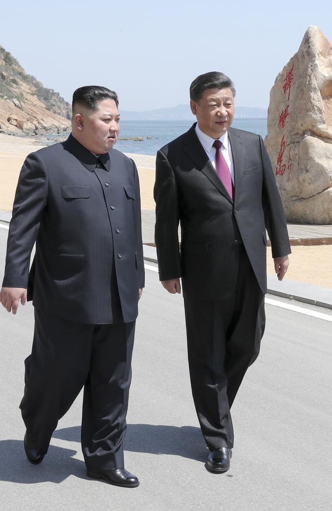 Chinese President Xi Jinping, right, walks with North Korean leader Kim Jong-un during a meeting in Dalian in northeastern China's Liaoning Province. Picture: AP