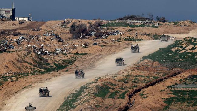 A picture taken from a position in southern Israel along the border with the Gaza Strip, shows Israeli army vehicles driving on a road in Gaza. Picture: AFP