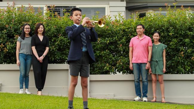 The Su family watches Benjamin sound the Last Post in preparation for the Anzac Day Dawn Service on Saturday. Picture: Justin Lloyd