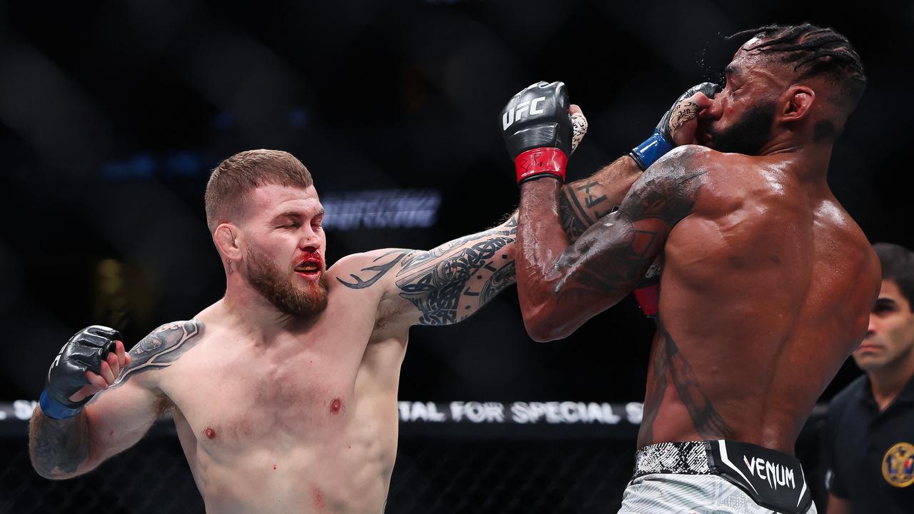 A bloodied Jake Matthews takes the fight to Phil Rowe. (Photo by Luke Hales/Getty Images via AFP)