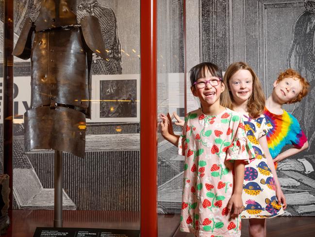 MELBOURNE, NOVEMBER 23, 2023: A rejig at the State Library has landed Ned Kellys armour in the Redmond Barry Reading Room. Ashley Yii (glasses), Neve Pianta and Ned Schrever check out Neds armour. Picture: Mark Stewart