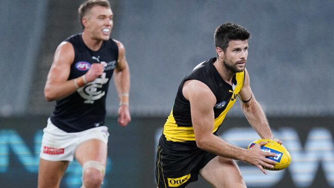 Trent Cotchin runs away from Patrick Cripps.