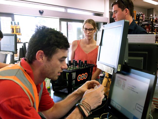 <s1>Sophie Kirkham and Scott McDonald get their IDs checked at the Parap BWS following the BDR’s introduction.</s1> Picture: Justin Kennedy