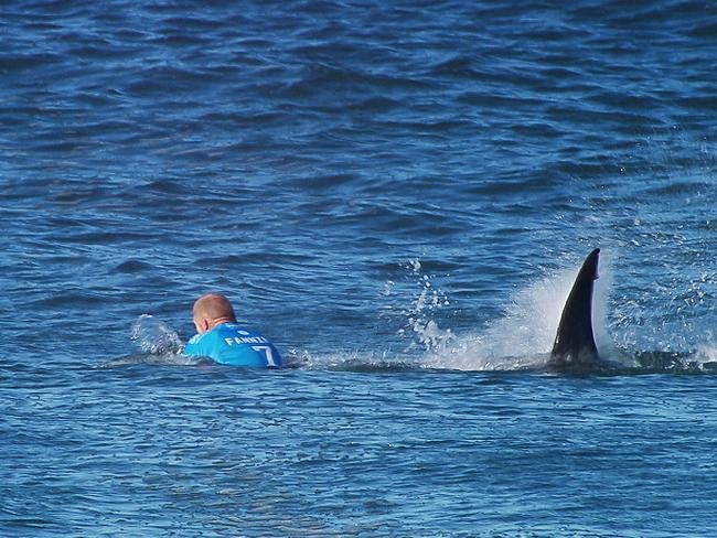 The moment the fin of a great white shark surfaced behind world champion surfer Mick Fanning.