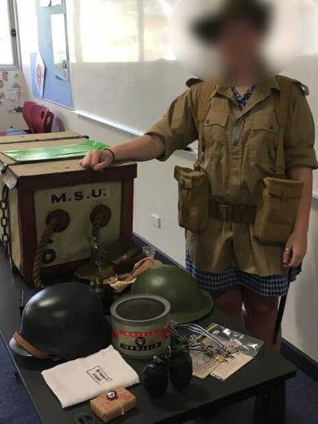 A schoolgirl with war memorabilia including a replica Zyklon B canister. Picture: Supplied.