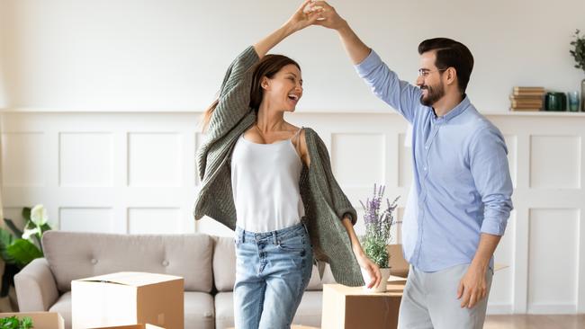 Overjoyed young Caucasian couple renters have fun excited moving in new home together. Happy man and woman tenants dance enjoy relocation day to own house. Relocation, real estate, rent concept.