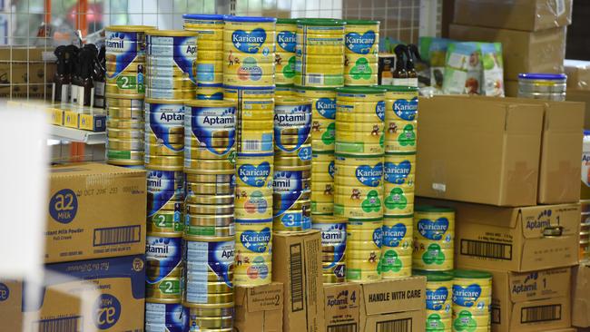 Cans of baby formula stacked up in a shop.