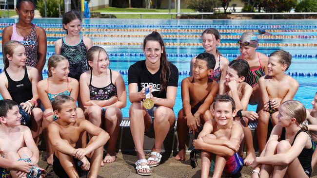 Triple Olympic gold medallist Kaylee McKeown shows off one of her medals to junior Cairns swimmers during a clinic at the Woree Sports and Aquatic Centre. Picture: Brendan Radke