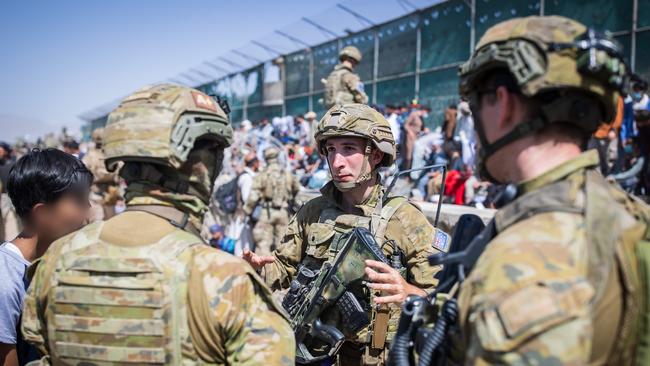 Members of the 1st Battalion, Royal Australian Regiment ready combat team assist the Department of Foreign Affairs and Trade with locating Afghan Australian visa holders attempting to enter the congested Abbey Gate at Hamid Karzai International Airport.