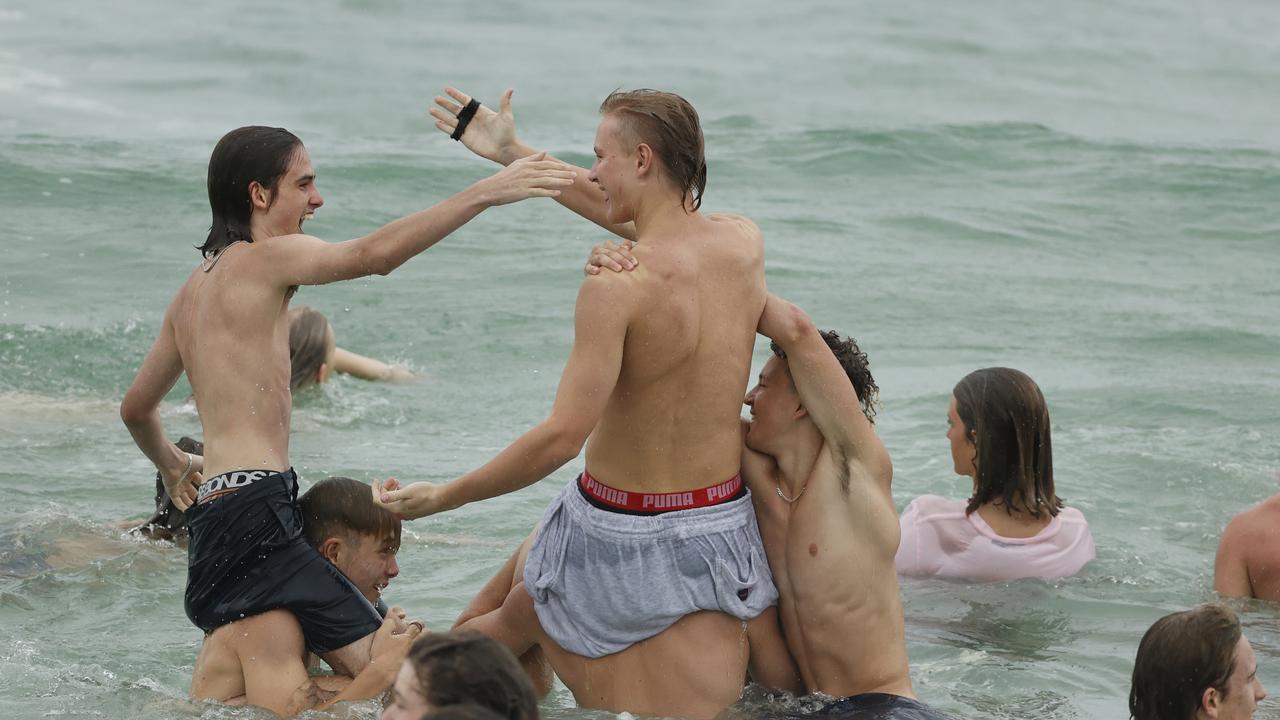 Family and friends of 16-year-old alleged stabbing victim Balin Stewart gather to pay tribute on his home beach at Buddina. Picture: Lachie Millard