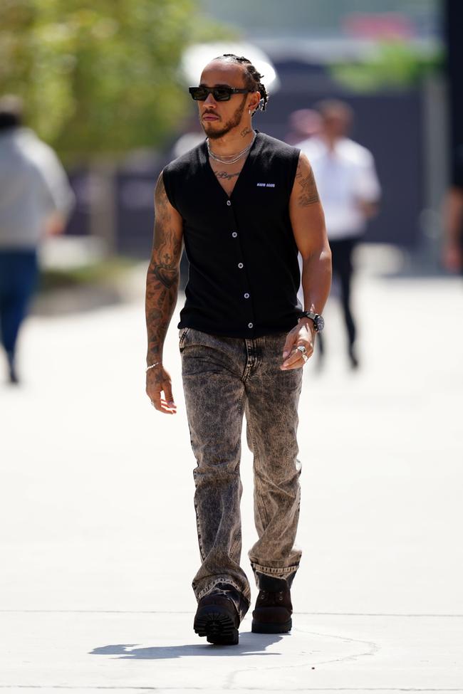 Lewis Hamilton wears a Miu Miu vest and jeans, Retrosuperfuture sunglasses, and Tiffany & Co. earrings at the Bahrain Grand Prix.