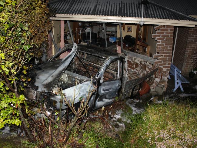 The charred shell of a ute which was set alight before rolling into this house at Glenorchy last week.