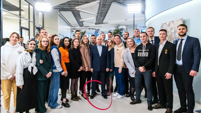 Russian President Vladimir Putin wearing high heeled shoes while posing with students from Moscow State University. Picture: AFP