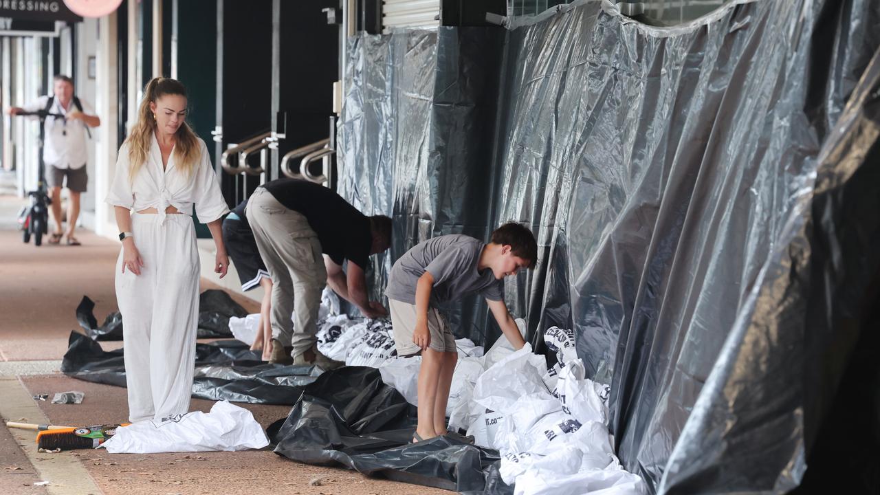 Brothers Casey Williams 12 and Luke Williams 13, with dad Gregg Williams and Hayley Van Twest lend a hand sandbagging at Cafe 7 in Paradise Point. Picture: Glenn Hampson