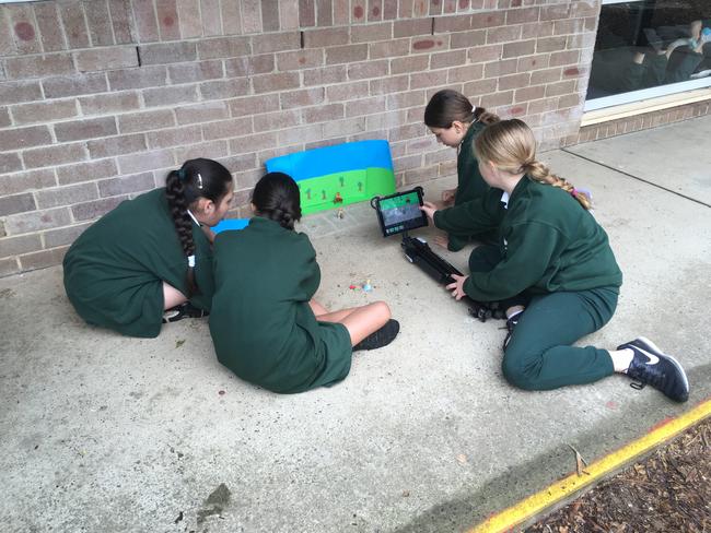 On Tuesday, students did school work on the ground of an undercover walkway as the outdoor lunch tables had been soaked by rain and there’s no break out space in demountables.