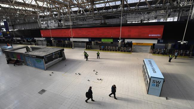 Police officers and National Rail staff patrol an empty Waterloo Station. Picture: Getty Images.