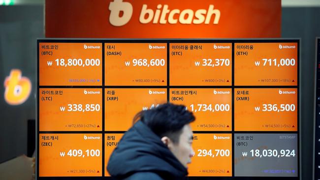 A man walks past an electric board showing exchange rates in won for cryptocurrencies — including bitcoin, top left — at an exchange in Seoul earlier this month. Picture: Reuters