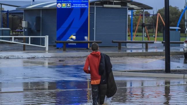 A Salisbury resident braves the flood waters. Picture: Roy VanDerVegt