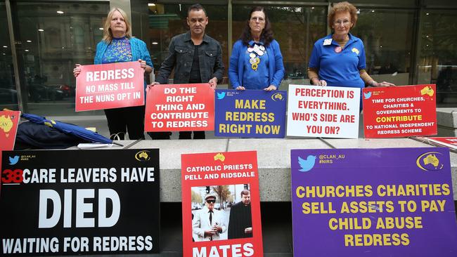 Protesters hold signs outside Melbourne County Court. Picture: Michael Dodge