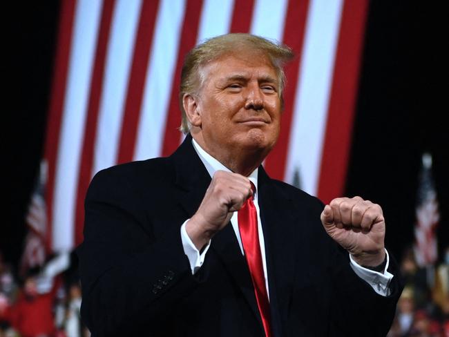 (FILES) In this file photo taken on December 05, 2020 US President Donald Trump holds up his fists at the end of a rally to support Republican Senate candidates at Valdosta Regional Airport in Valdosta, Georgia. - Former US president Donald Trump will provide commentary for the upcoming fight between former world heavyweight champion Evander Holyfield and Brazilian mixed martial arts star Vitor Belfort, the digital channel that will stream the bout announced on September 8, 2021. (Photo by Andrew CABALLERO-REYNOLDS / AFP)