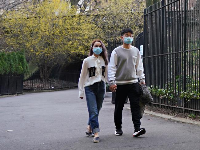 A couple hold hands while wearing protective masks in Central Park as the coronavirus continues to spread across the United States. Picture: Getty