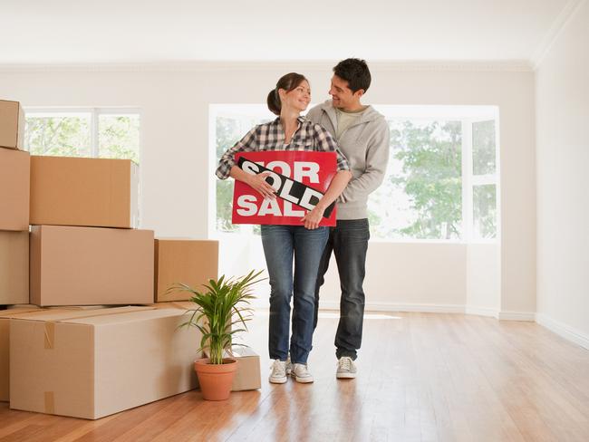 Couple holding sold sign for their new house stock photo - for Herald Sun realestate. Source: iStock