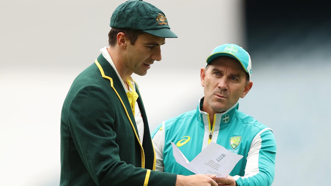 MELBOURNE, AUSTRALIA - DECEMBER 26: Pat Cummins of Australia and Australia head coach Justin Langer are seen with England's team list during day one of the Third Test match in the Ashes series between Australia and England at Melbourne Cricket Ground on December 26, 2021 in Melbourne, Australia. (Photo by Robert Cianflone/Getty Images)
