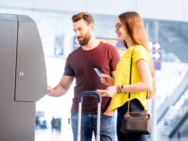 ESCAPE: Young couple withdrawing money using ATM at the airport during their travel Picture: Istock