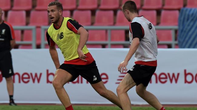 Liverpool football player Jordan Henderson (L) controls the ball during a team training session at Rajamangala stadium in Bangkok on July 13, 2015. Liverpool football team will play an exhibition match with Thai Premier League All-Stars team at Rajamangala stadium in Bangkok on July 14. AFP PHOTO / PORNCHAI KITTIWONGSAKUL