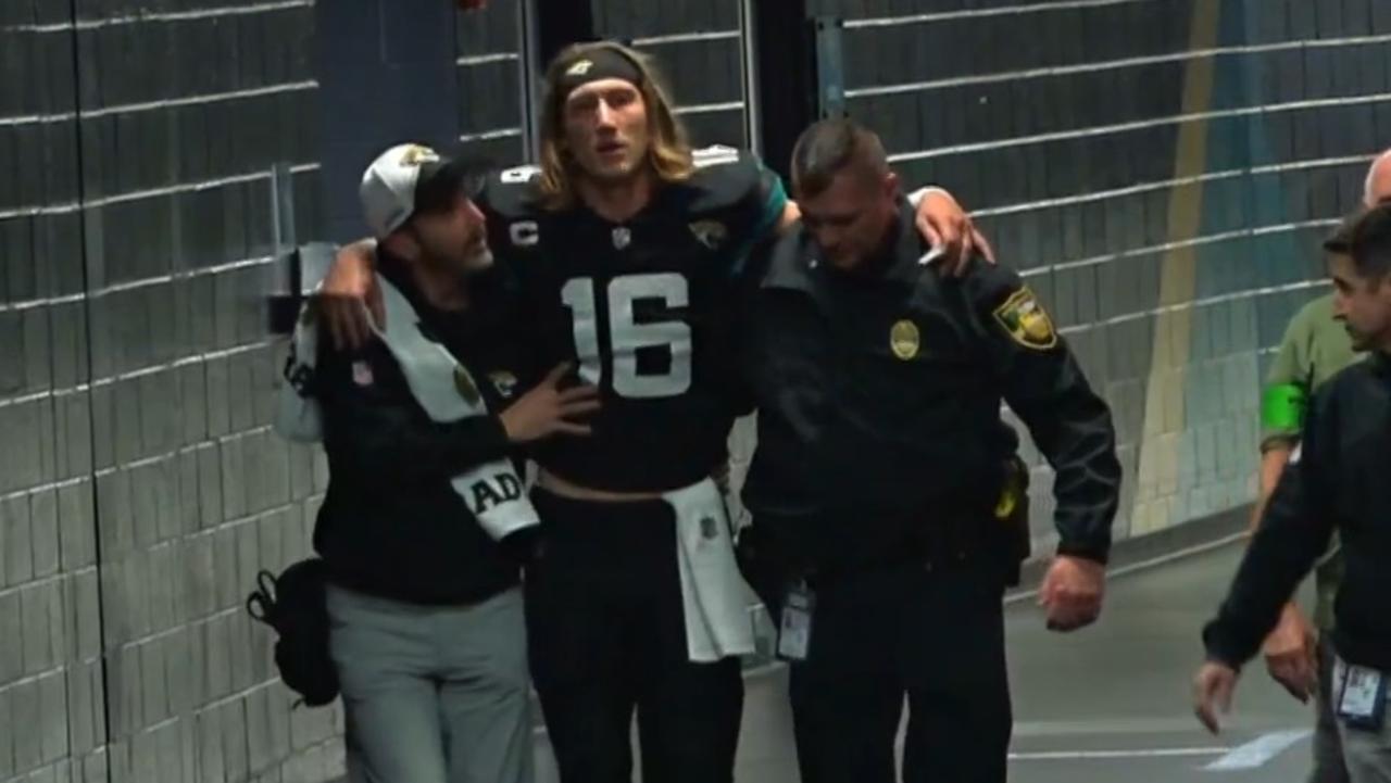 Trevor Lawrence is walked to the locker room after his ankle injury.