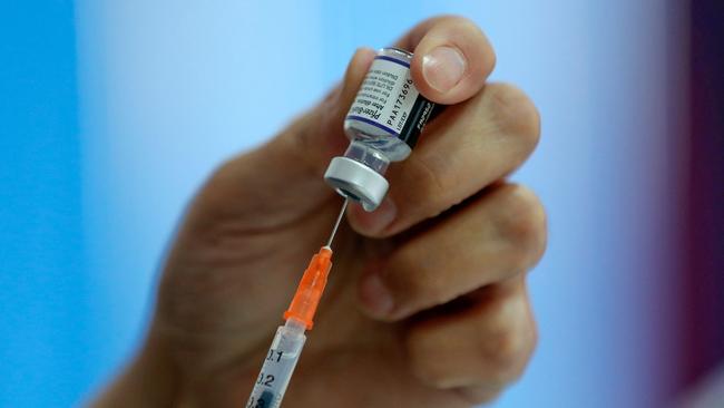 A health worker prepares a dose of the Pfizer-BioNTech vaccine against COVID-19 at a vaccination center in Santiago, on January 20, 2022. - Chile registered this Thursday a new record of daily infections, with 12,500 new infected, the highest number in the entire pandemic, in one of the countries with the highest percentage of its population vaccinated and that this Thursday began to apply the fourth dose to health personnel. (Photo by JAVIER TORRES / AFP)