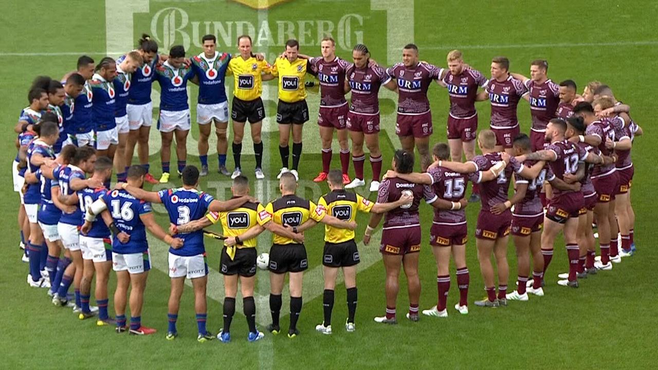 Manly and Warriors players embrace for a minute's silence in Christchurch.