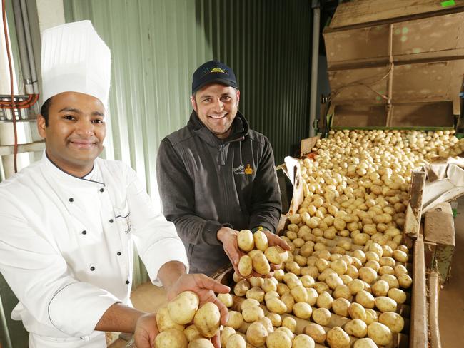 The Langham chef Dipesh Kadam helps Richard Hawkes sort Hawkes Farm spuds. Picture Norm Oorloff