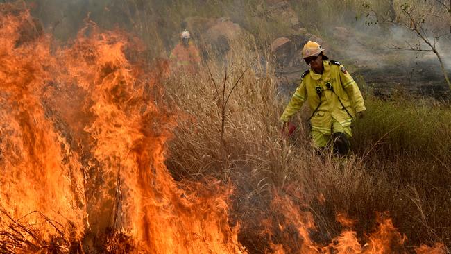 A station officer back burns on the West End side of Castle Hill during previous reduction burns. Picture: Evan Morgan