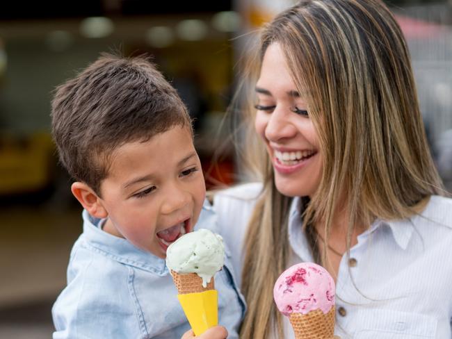 Mother and son eating an ice cream and looking very happy - family concepts