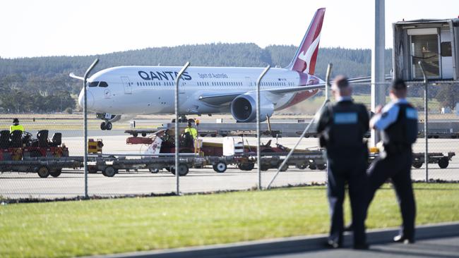 Police watch as Qantas flight lands in Canberra, ACT. Picture: Getty Images