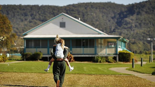 A mother gives her daughter a piggyback ride to their cottage at the Emu Plains facility. Picture: Sam Ruttyn