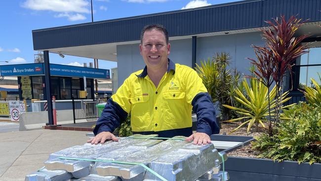 Gladstone Mayor Matt Burnett behind a stack of aluminium ingots at the Rio Tinto Boyne smelter.