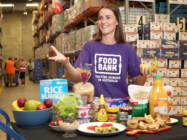 Malindi Trehearn poses with breakfast food at the Food Bank warehouse in Brisbane. Picture: AAP