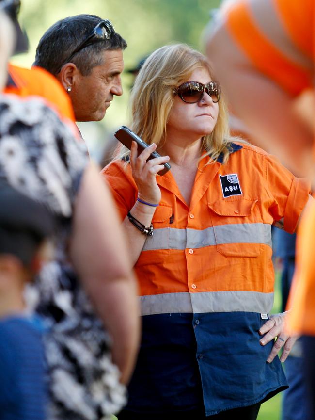 Workers tune in on ABC radio interview while at the rally. Picture: Chloe Smith.