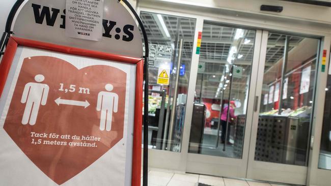 A sign reminds customers about social distancing at the entrance to a grocery store in central Stockholm, Sweden. Picture: AFP