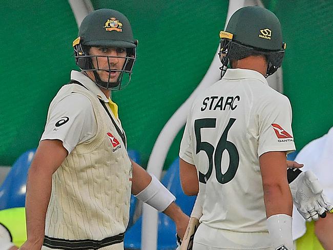 Pat Cummins and Mitchell Starc leave the field after bad light ruined play. Picture: AFP