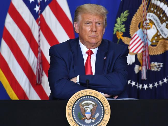 US President Donald Trump listens to officials during a roundtable discussion on community safety, at Mary D. Bradford High School in in Kenosha, Wisconsin on September 1, 2020. - Trump said Tuesday on a visit to protest-hit Kenosha, Wisconsin that recent anti-police demonstrations in the city were acts of "domestic terror" committed by violent mobs. "These are not acts of peaceful protest but really domestic terror," Trump said, describing multiple nights of angry demonstrations last week after a white police officer in Kenosha shot a black man in the back at close range. (Photo by MANDEL NGAN / AFP)